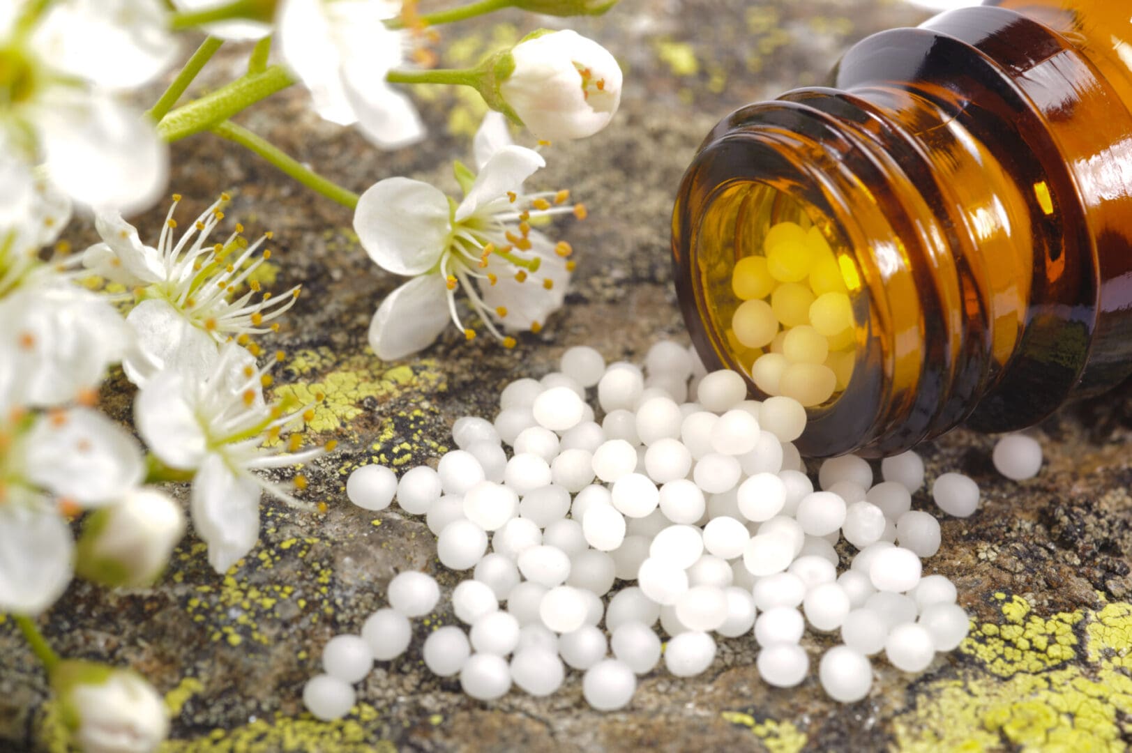 Homeopathic pills spilling from bottle.