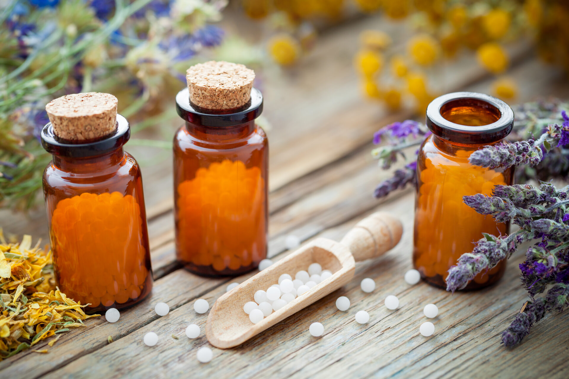 Homeopathic remedies with herbs and spoon.