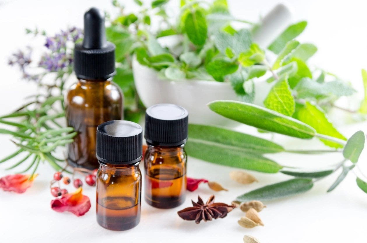 A table topped with bottles of oils and herbs.